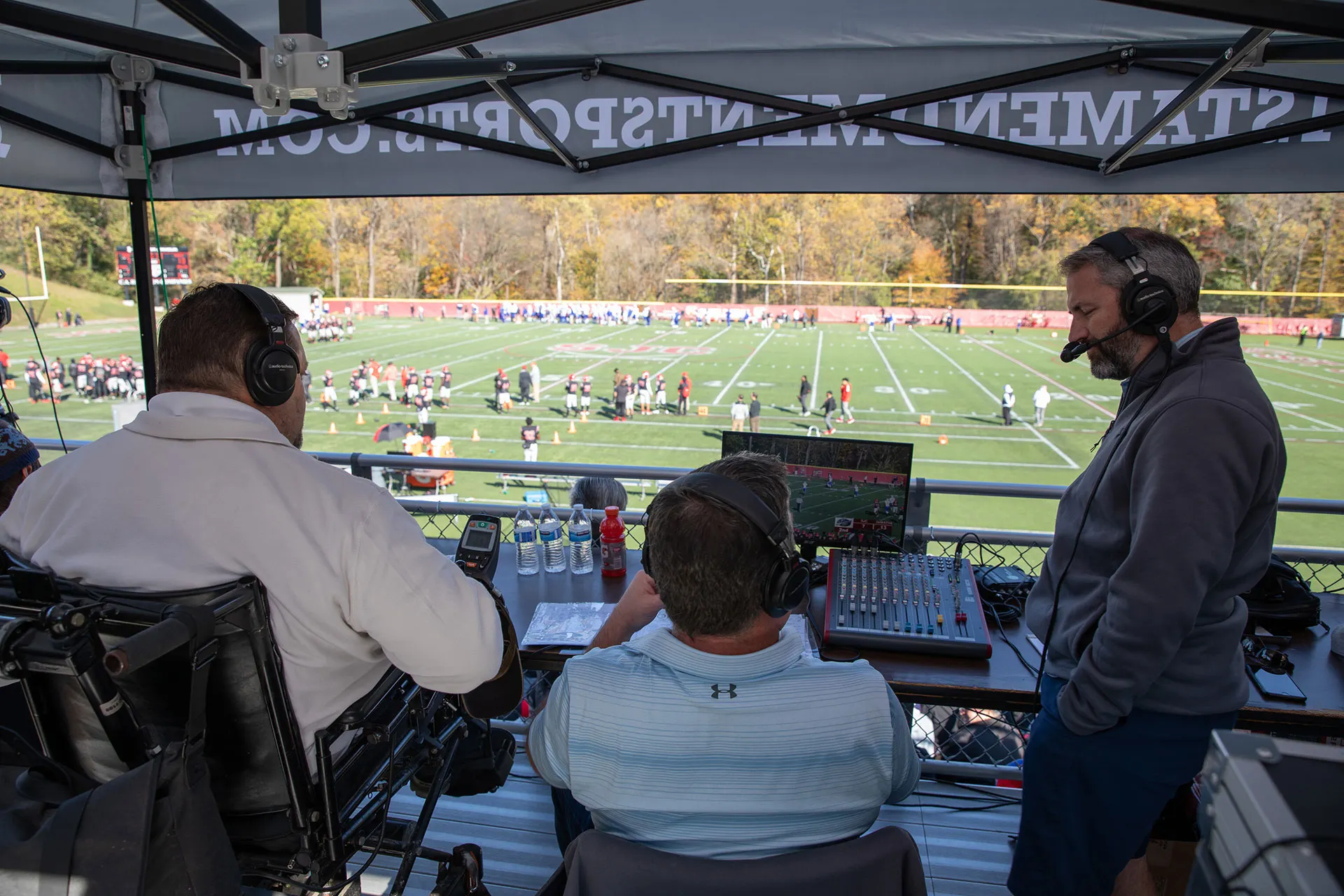 Two broadcasters on headsets during live commentary.