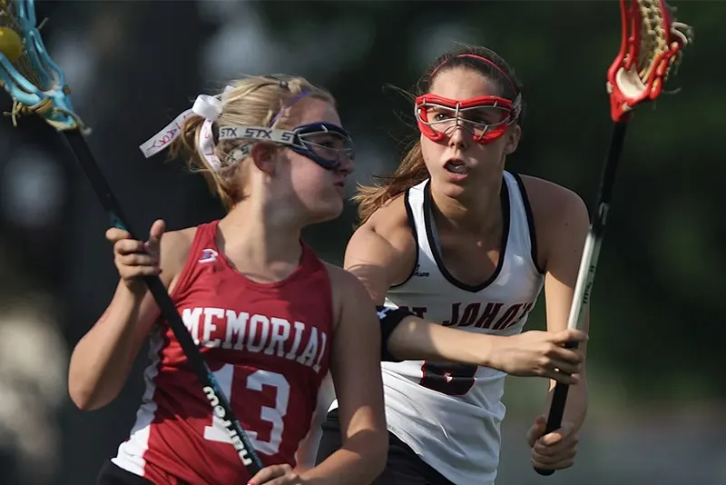 Women's lacrosse players contesting a draw during a filmed match.